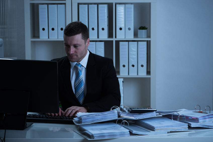 man in dark suit working in his office